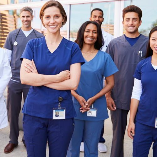 Team of healthcare workers with ID badges outside hospital