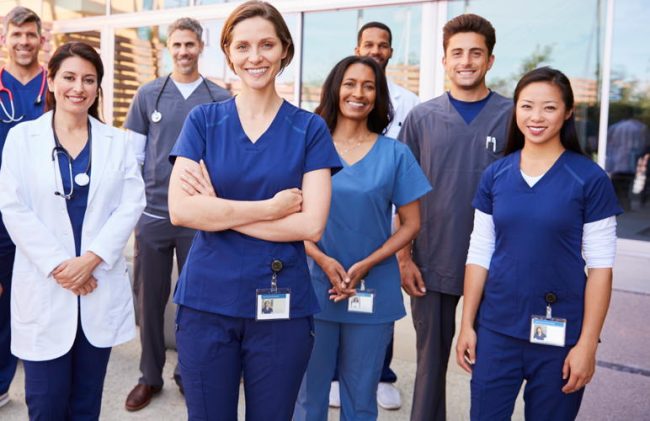 Team of healthcare workers with ID badges outside hospital