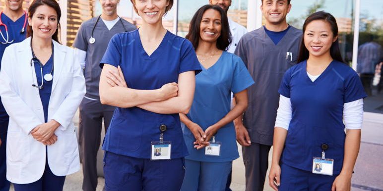 Team of healthcare workers with ID badges outside hospital